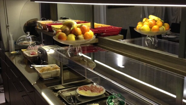 A buffet setup with various food items and condiments. - Brenta Milano (Milan)