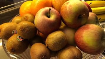 A display of fruits including kiwis, apples, oranges, and bananas.