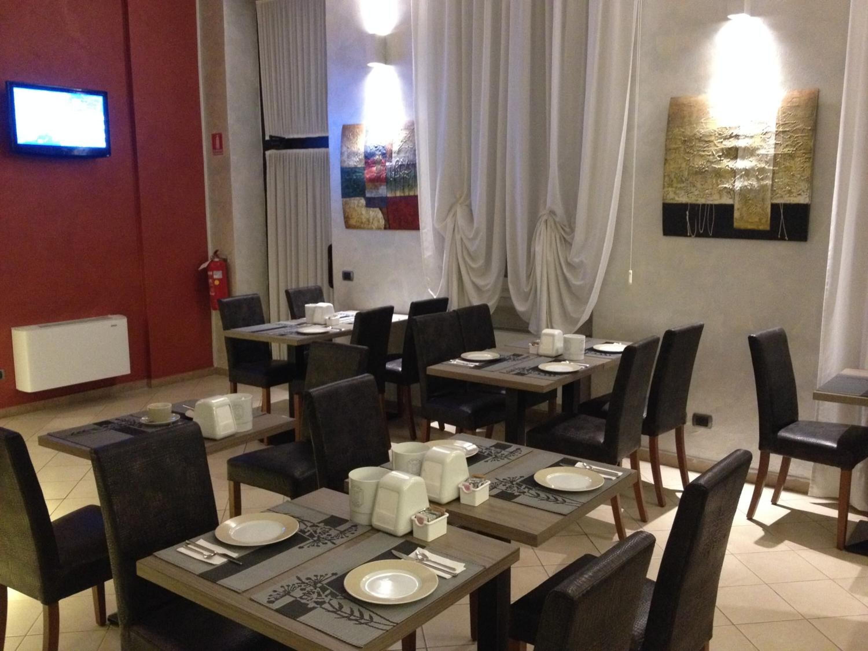 A dining area with tables set for four, chairs, and a fire extinguisher on the wall.