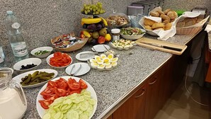 A buffet table with various food items including fruits, vegetables, bread, and condiments. - Aparthotel Adler (Kraków)