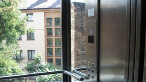 An elevator interior with a view of a building outside. - Aparthotel Adler (Kraków)