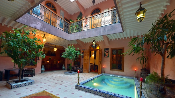 Un vaste atrium doté d’une piscine centrale, de nombreux balcons et d’une végétation luxuriante.