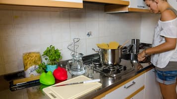 Full-sized fridge, stovetop, cookware/dishes/utensils