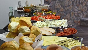 Una mesa de buffet con diversos alimentos, como pan, huevos y salsas.