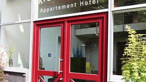 The exterior of the Zur KragenGasse Apartment Hotel with a red double door and a visible entrance. - Themen Hotel zur Kranengasse (Kranenburg)