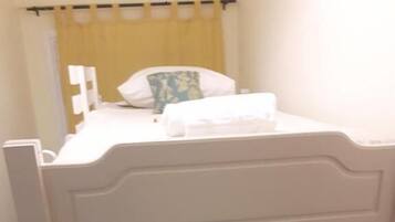 Cozy retreat with a bunk bed featuring two comfortable mattresses and a nightstand with a lamp.