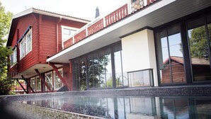 A modern house with a swimming pool, large windows, and a red exterior. - Åkerblads Gästgiveri Hotell Spa (Tallberg)