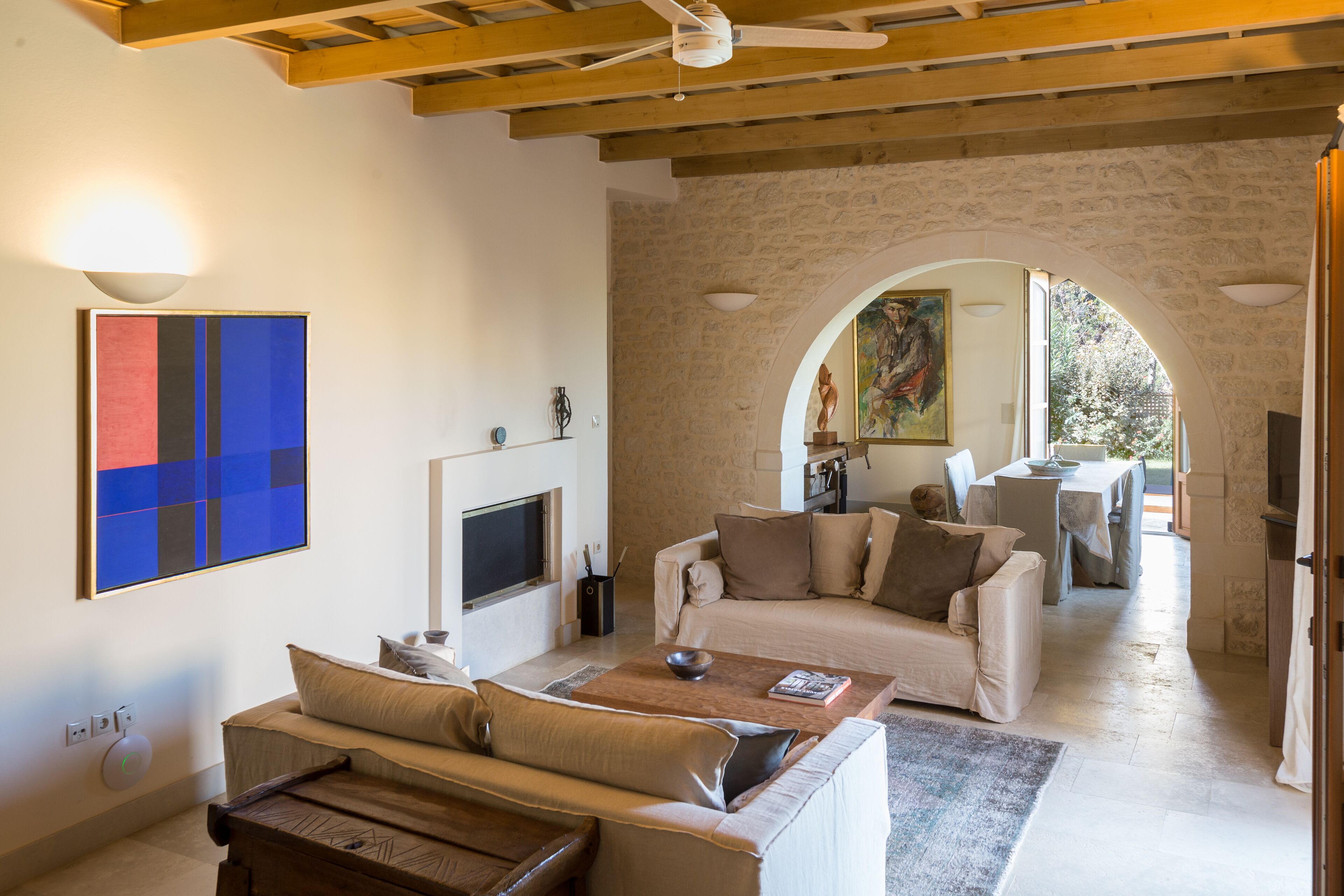 A living room with a stone wall, a TV, a sofa, and a coffee table.