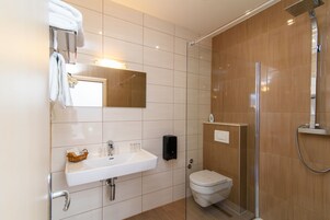 Un bagno moderno con lavandino bianco, specchio e cabina doccia in vetro.