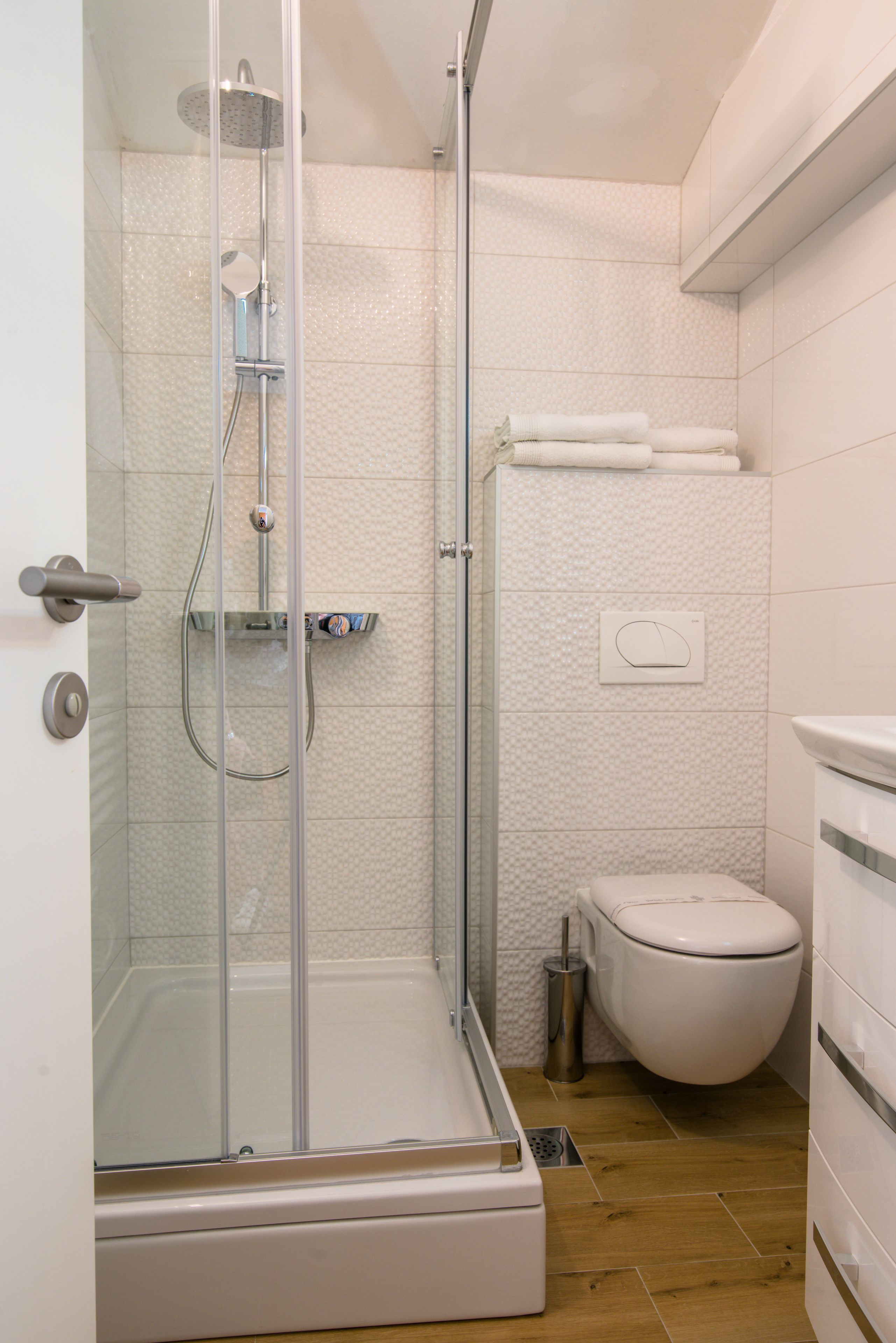 Un baño moderno con ducha de vidrio, inodoro y lavamanos.