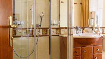 A modern bathroom with a glass-enclosed shower, a wooden vanity, and a large mirror.