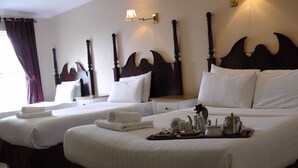 A hotel room with two beds, each with white linens and a dark wooden headboard. There is a tray with breakfast items on the larger bed. - Shamrock Inn Hotel (Lahinch)