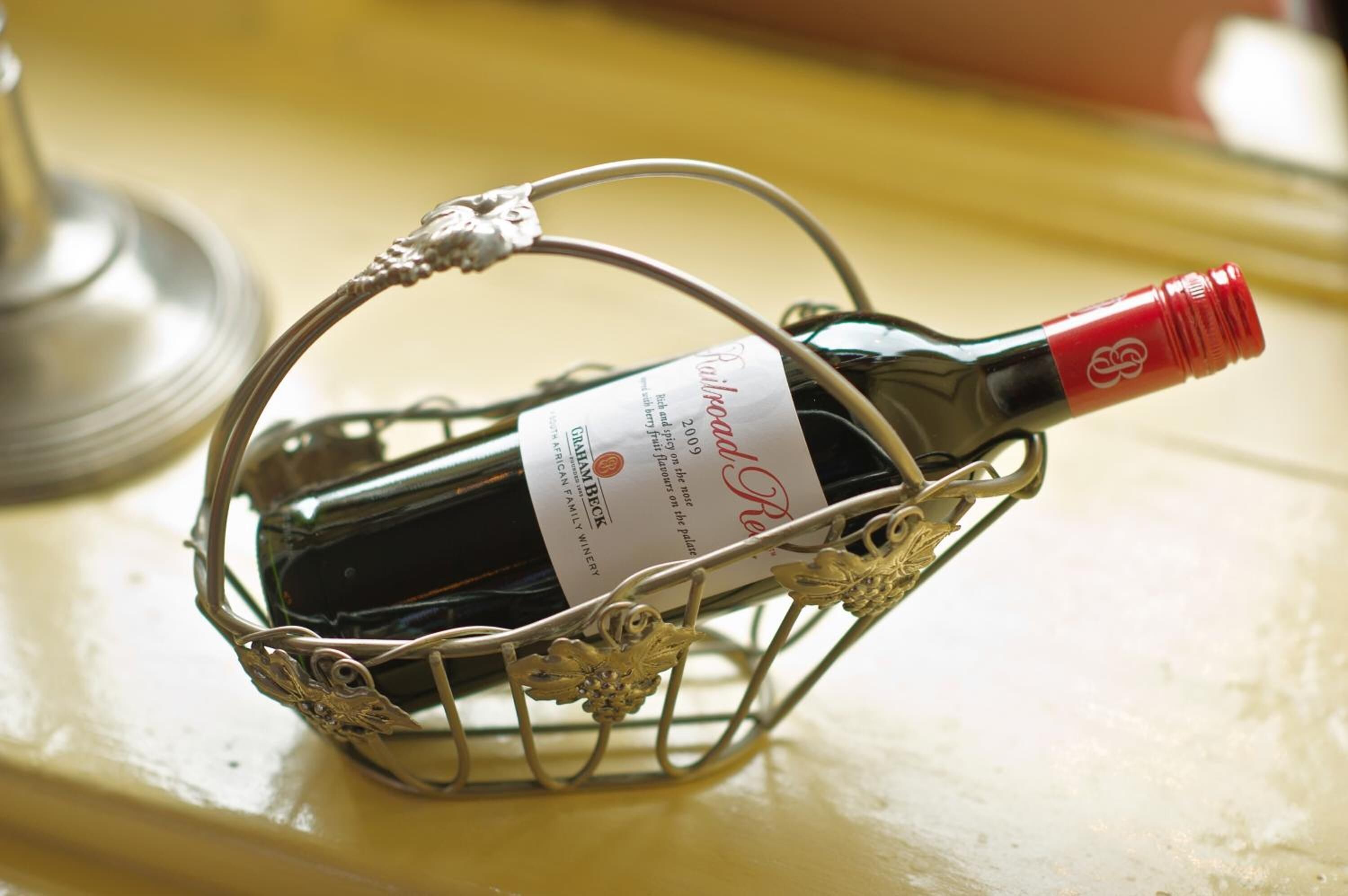 Una bottiglia di vino in un cesto di fili decorativo.