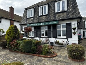 Een klassiek gebouw met een bord waarop staat: 'The White Lodge Bed & Breakfast'.