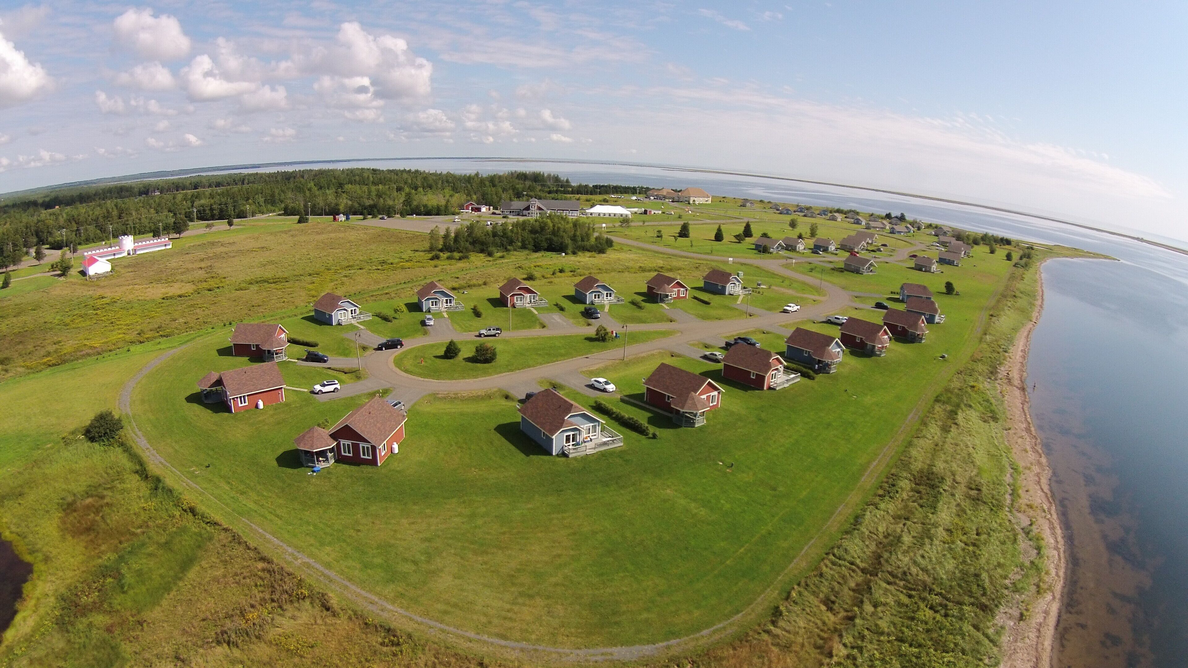 An aerial view of a residential area with houses arranged in a semi-circular pattern around a body of water.