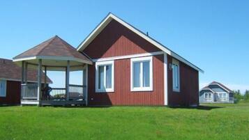 A red house with a covered porch and a small attached garage.