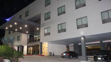 Um hotel com vários andares e área de estacionamento coberta.