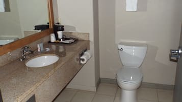 A bathroom with a sink, mirror, toilet, and towel rack.