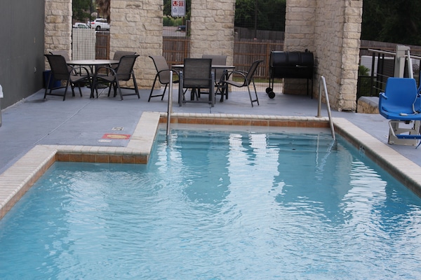 Una piscina al aire libre de temporada, sombrillas