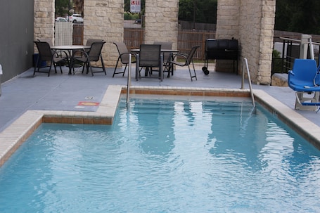 Una piscina al aire libre de temporada, sombrillas