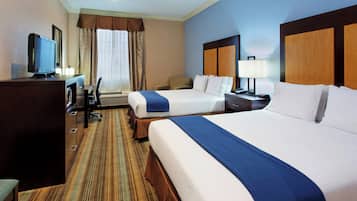 A hotel room with two beds, a desk with a computer, a chair, and a television.