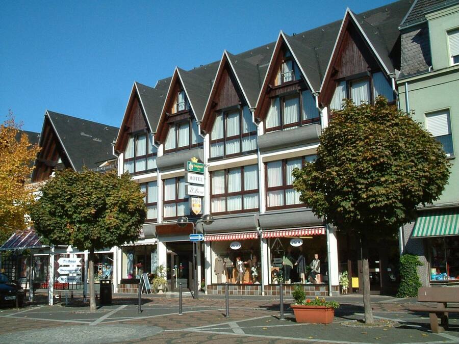 A hotel with a traditional European architectural style, featuring multiple gabled roofs and a prominent sign indicating it is a hotel.
