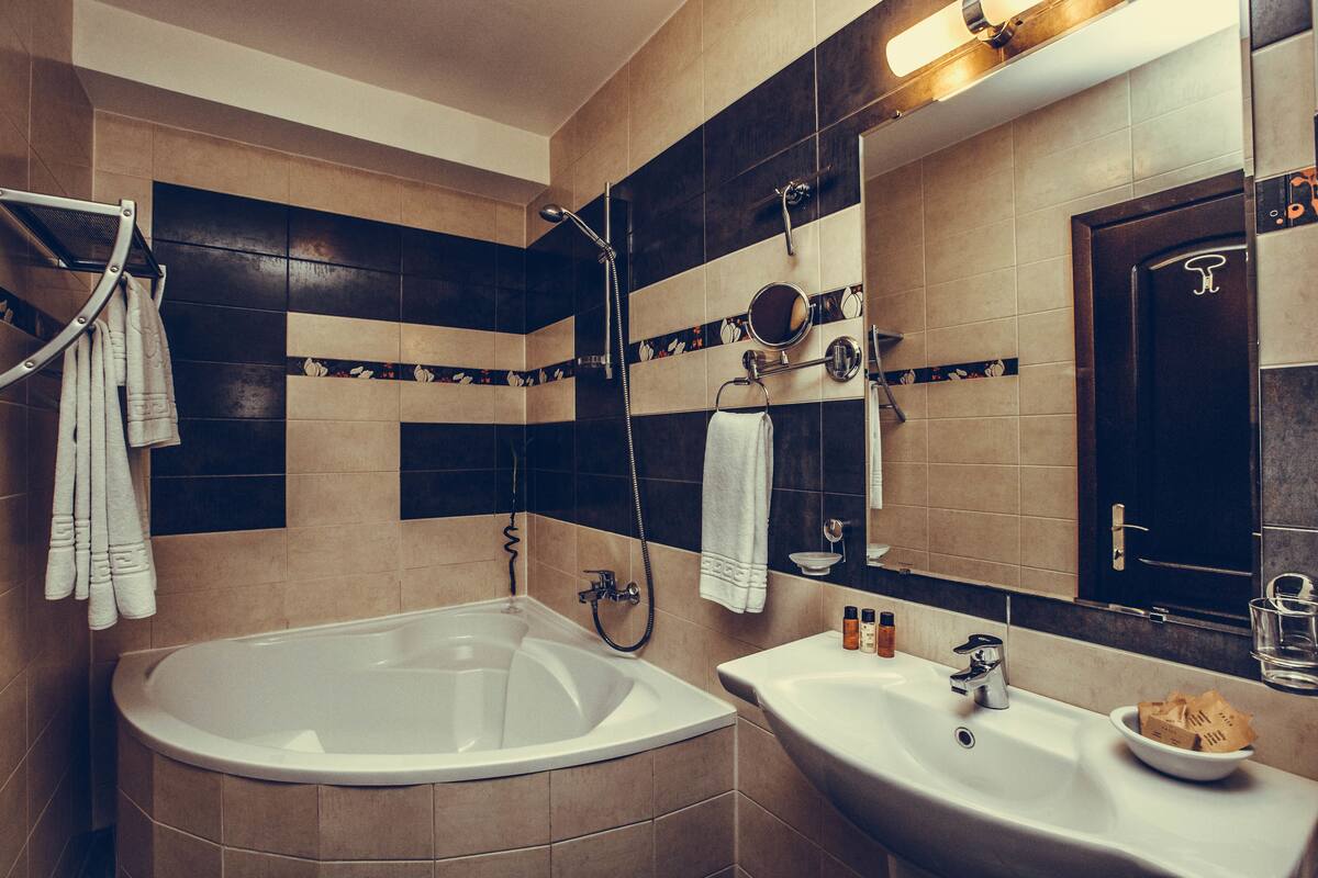 premium suite | bathroom | combined shower/bathtub, designer toiletries, hair dryer, bathrobes