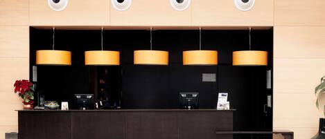 A reception desk with three pendant lights, a black counter, and a sign that reads "PRIVATE".
