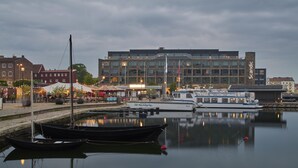 A waterfront area with boats docked, a building labeled "Scandic," and a restaurant with outdoor seating. - Scandic Karlskrona (Karlskrona)
