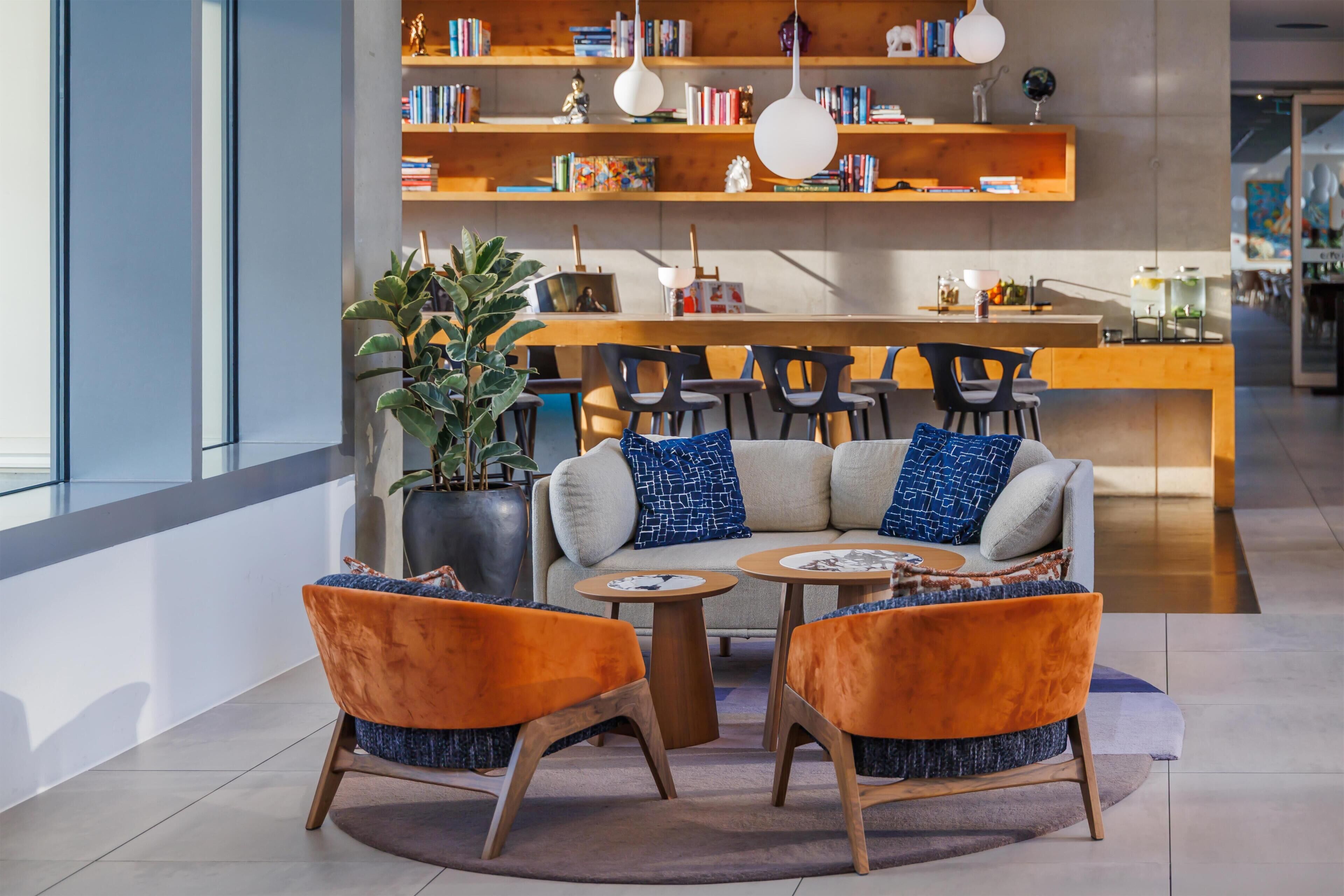 Un intérieur moderne comprenant un ensemble de canapés, une table basse et un coin repas avec des chaises et une table en bois.