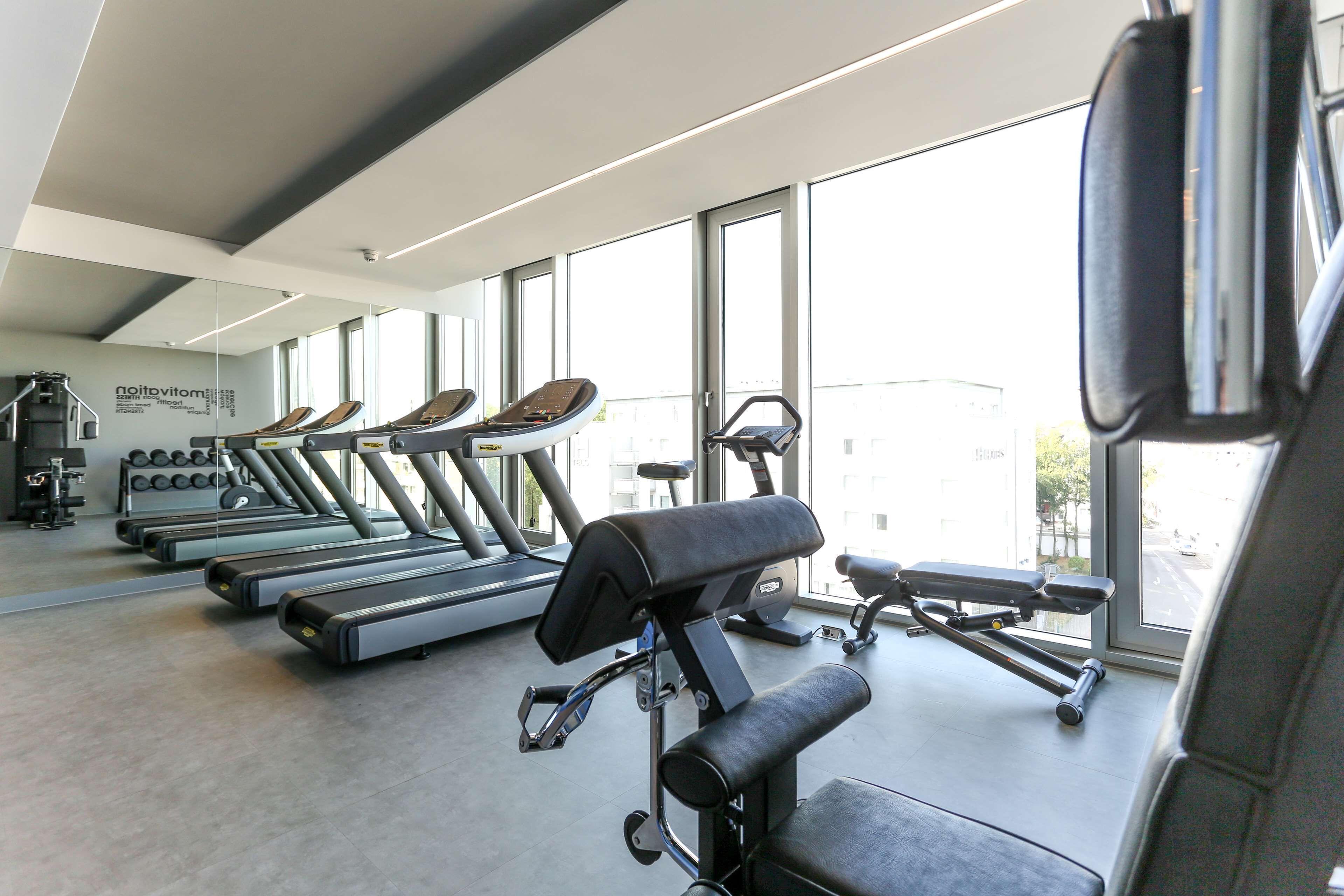 A gym with treadmills, a stationary bike, and a rowing machine.