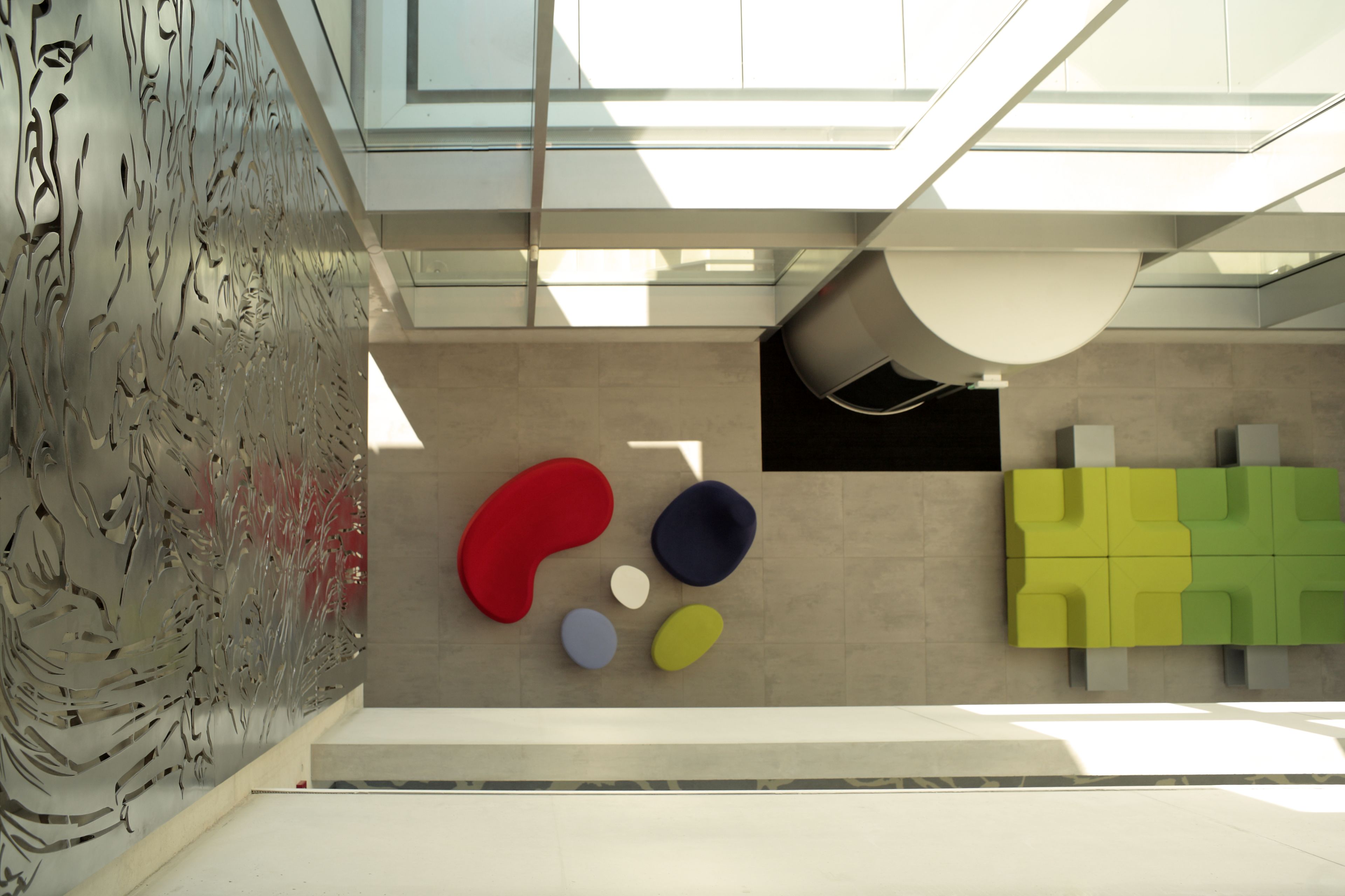 Ein modernes Interieur mit abstrakter Wandkunst, geometrischen Formen und einem Oberlicht.