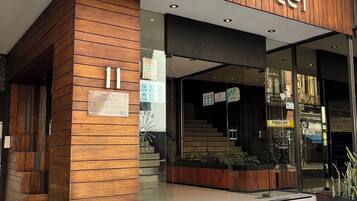 Exterior del Hotel Gilfer, con fachada de madera, entrada de vidrio y un cartel con el nombre del hotel.