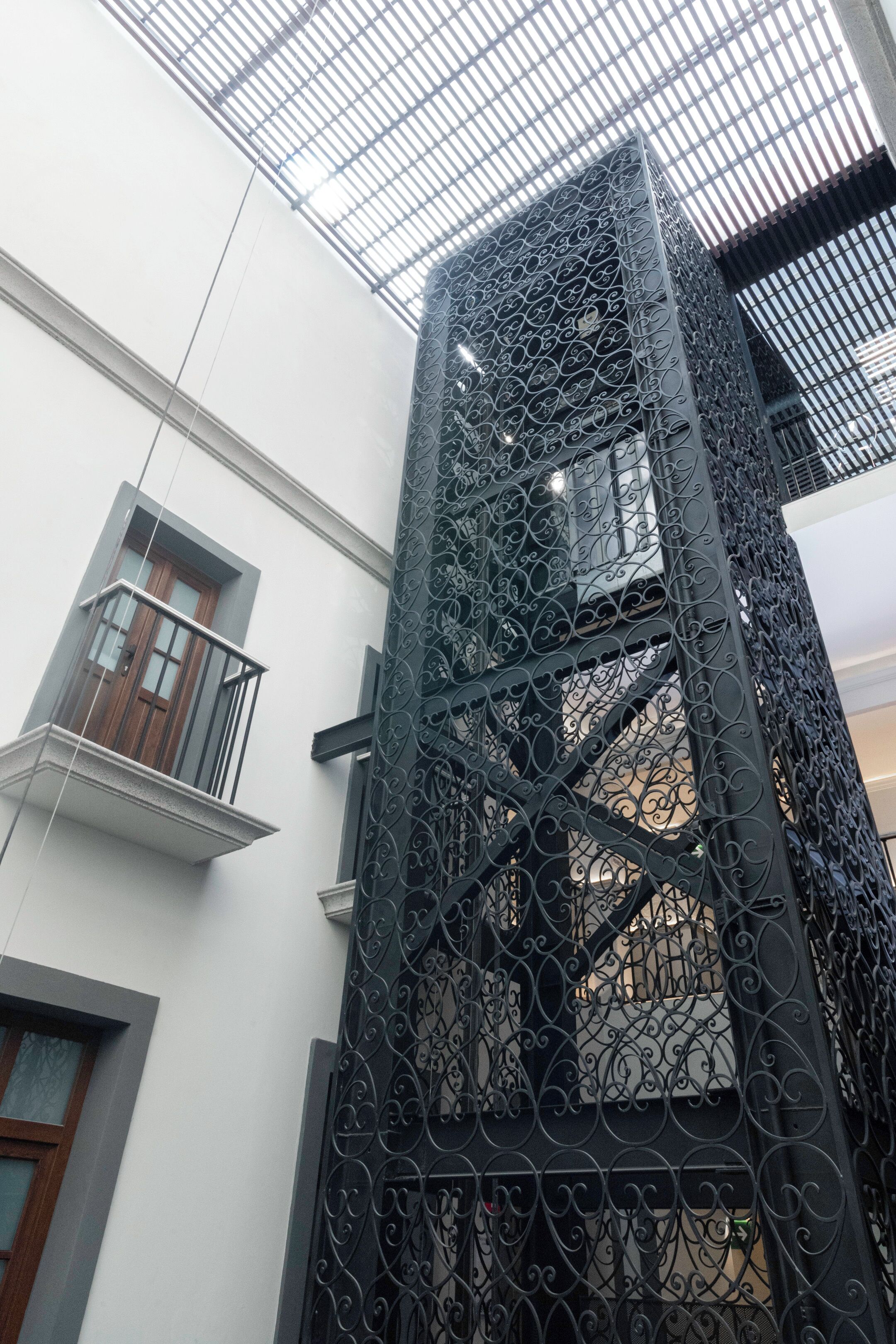 Un edificio con una escalera metálica y un balcón.