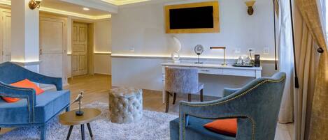 Een moderne woonkamer met een bank, fauteuil en een werkplek met een flatscreen televisie.