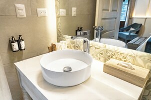 Un baño con un lavamanos blanco, un espejo y un dispensador de toallas.