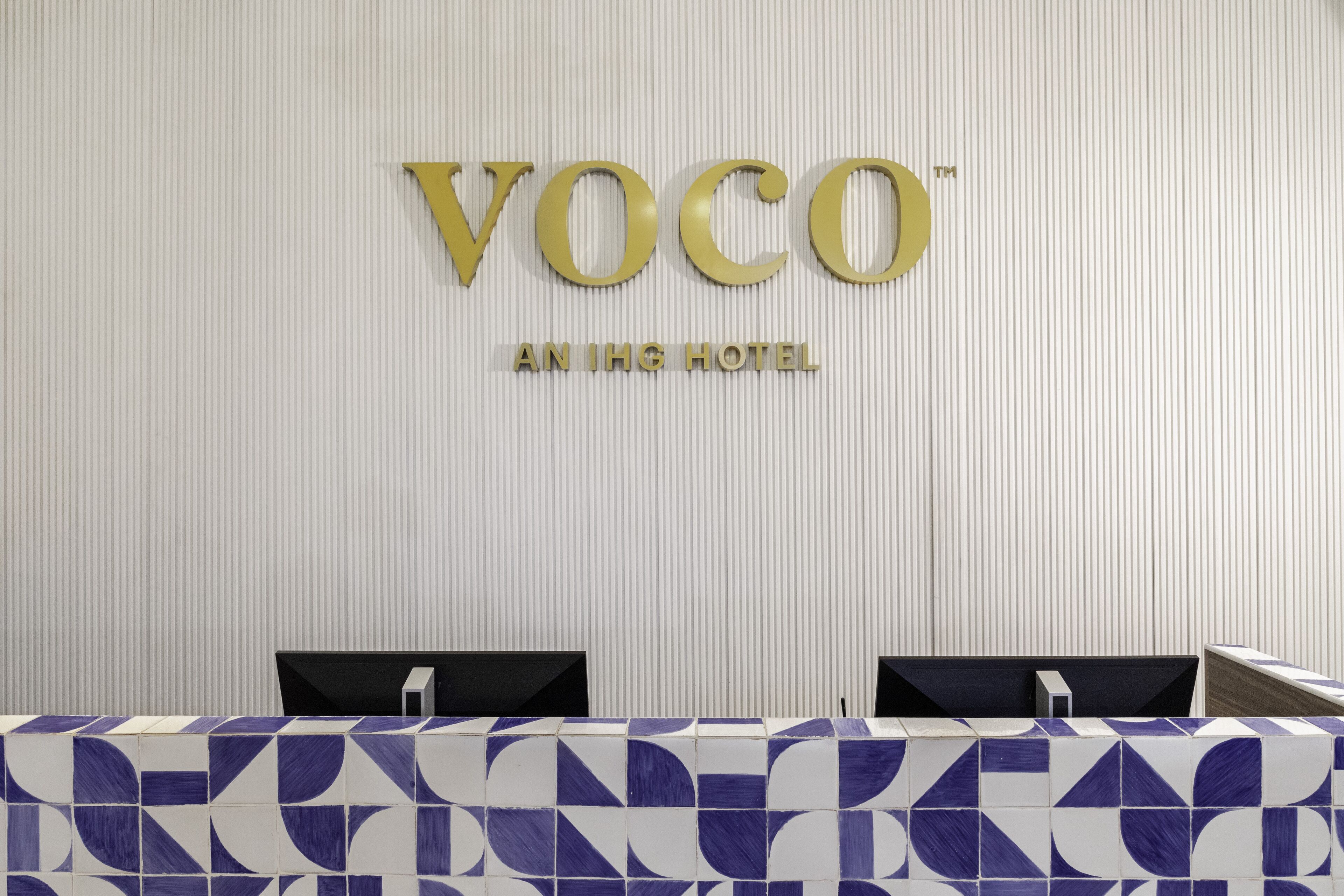 A reception area with a sign reading "VOCO AN IHG HOTEL".