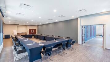 A conference room with a long table, chairs, and a whiteboard.