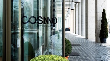 Das COSNO Hotel Berlin mit freiem Blick auf den Eingang und einem Blumentopf im Vordergrund.
