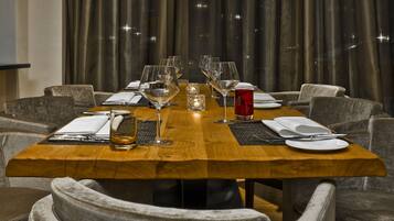A dining table set with multiple wine glasses, a red drink, and cutlery.