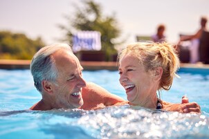 Una piscina al aire libre, sillones reclinables de piscina