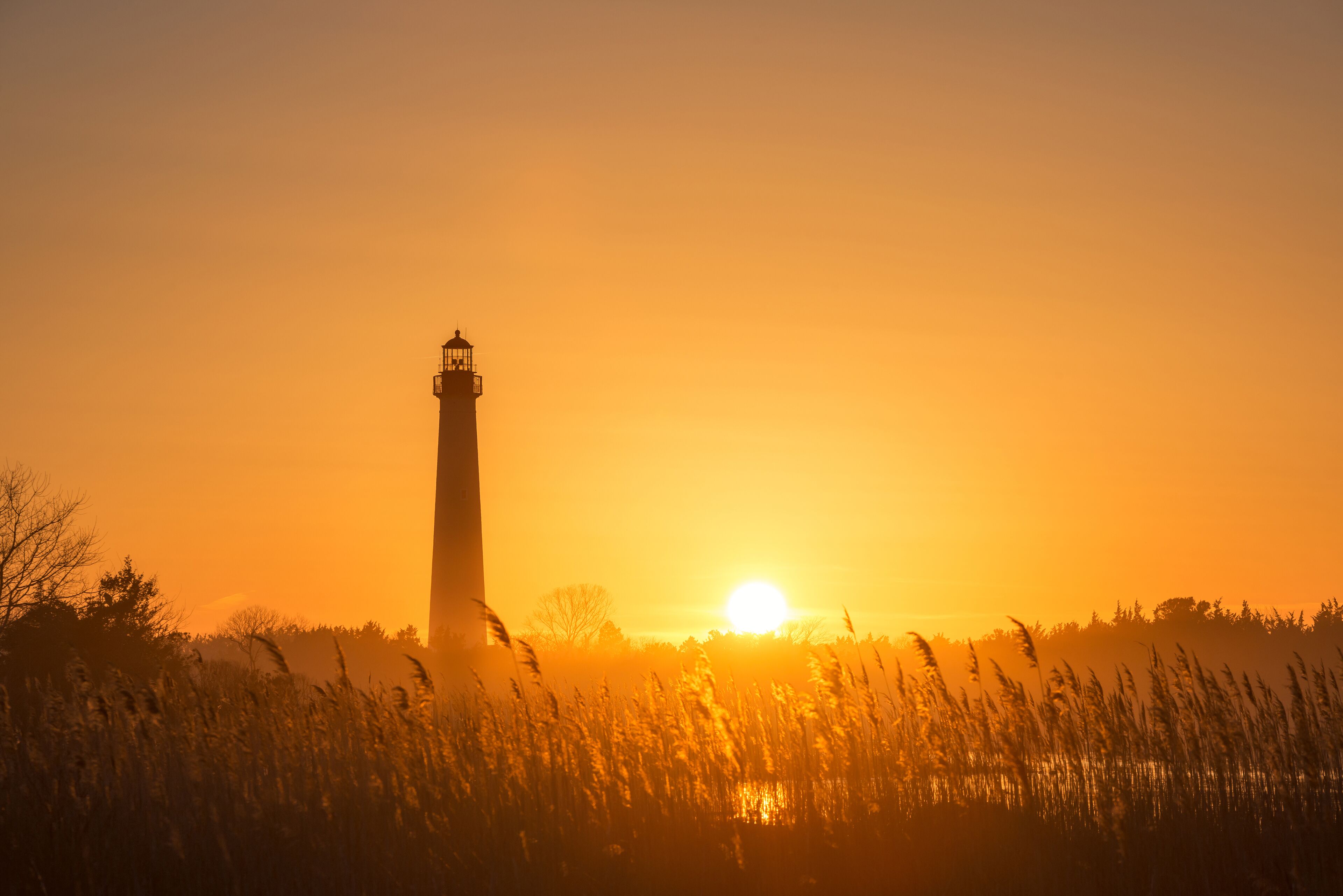 Silueta de un faro contra un atardecer.
