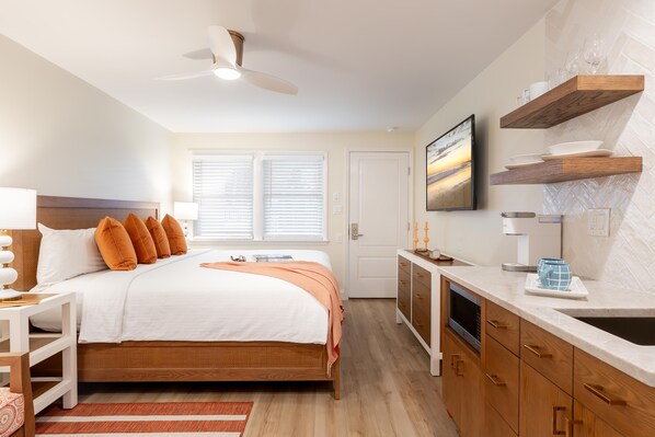 A bedroom with a bed, bedside table, lamp, and a window with blinds.