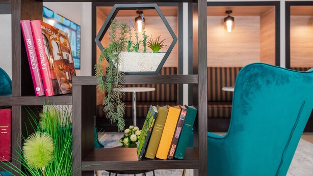 Una estantería con libros y una jardinera hexagonal con plantas.