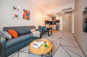 Una sala de estar moderna con un sofá, una mesa de centro y una obra de arte en la pared.