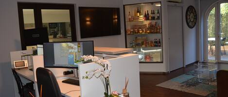A modern office space with a desk, computer, and a decorative orchid centerpiece.