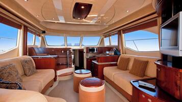 A yacht interior with a dining area, seating, and a TV.