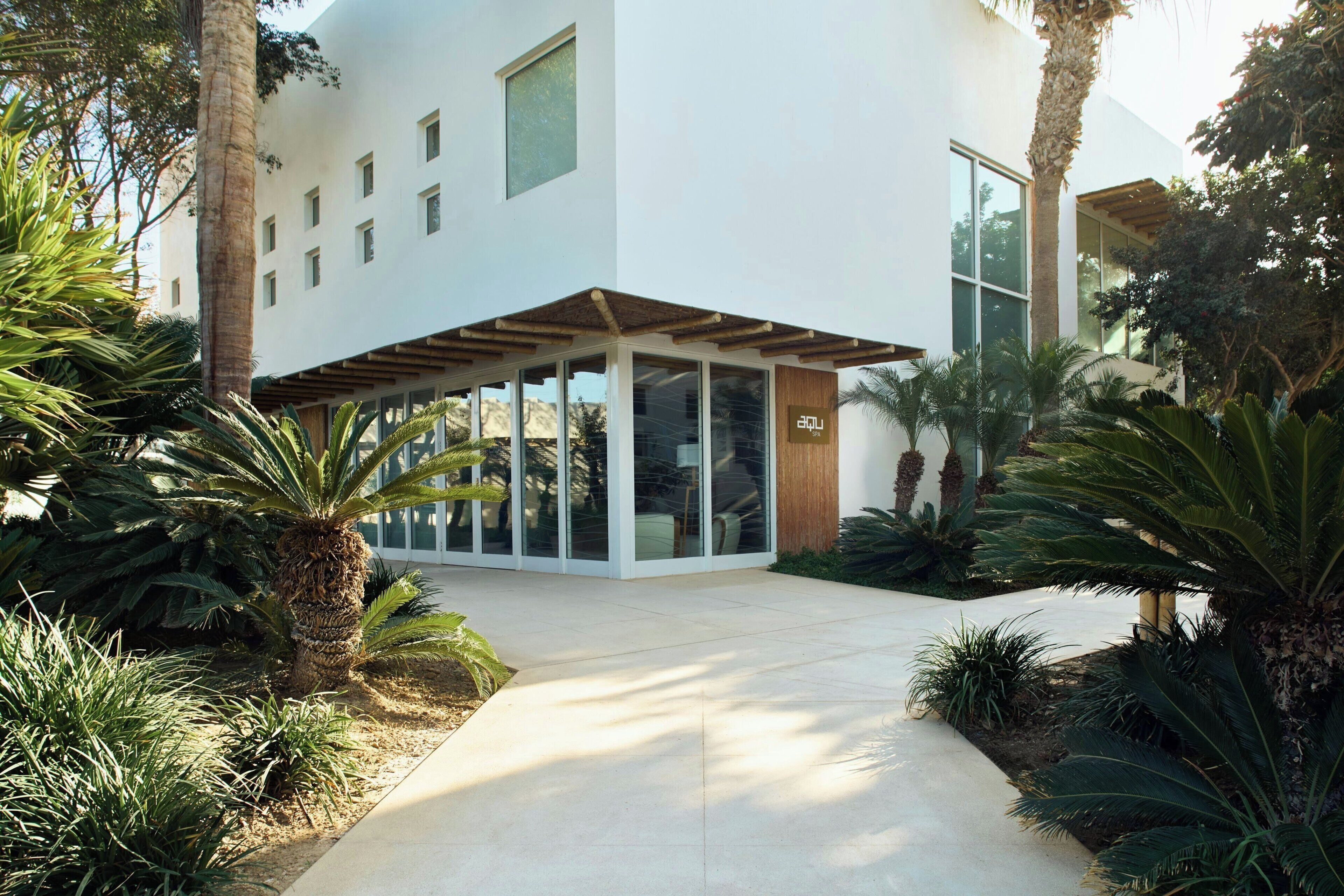 A modern building with a covered entrance, glass doors, and a sign indicating a spa.