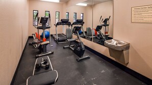 Un gimnasio con cintas de correr, elípticas y un banco de pesas.