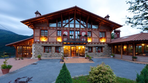 A large, rustic lodge with a stone facade, multiple windows, and a welcoming entrance. - Etxegana Hotel & Spa (Zeanuri)